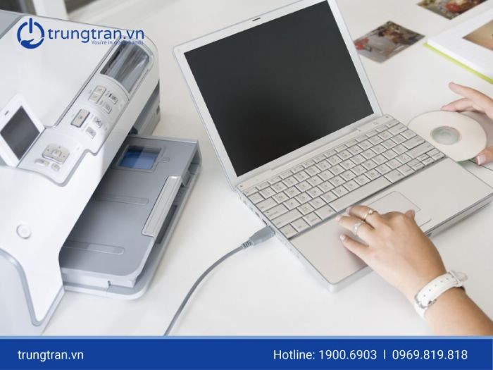 Người dùng cắm cáp USB từ máy in vào cổng laptop Dell