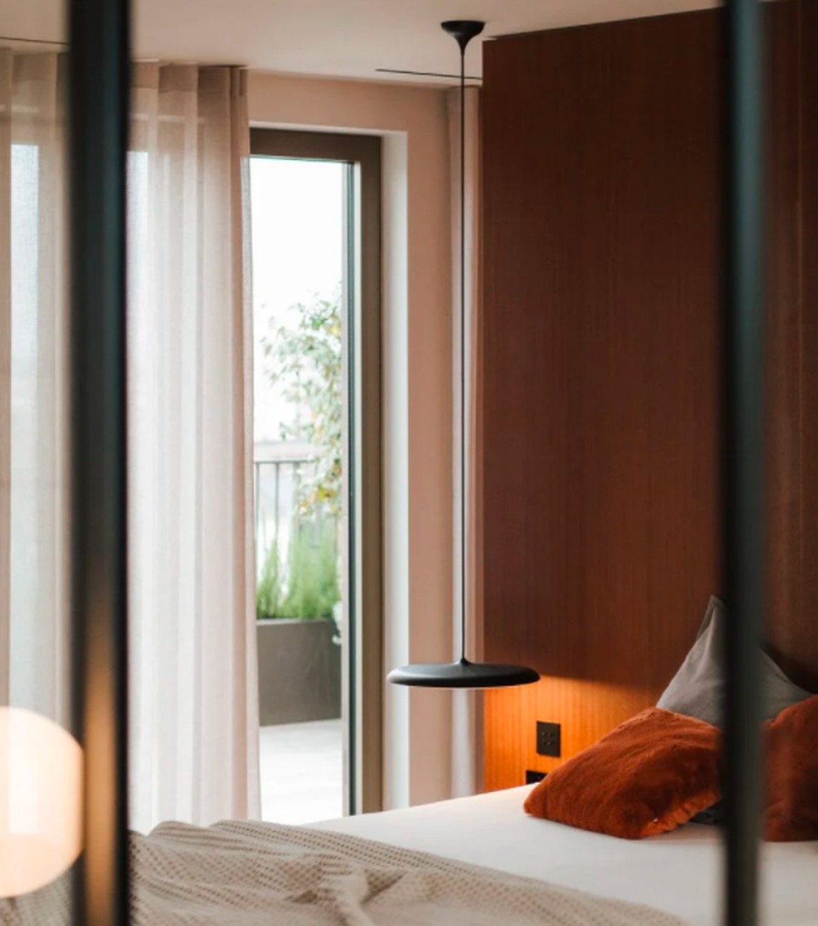 Tường ốp gỗ anh đào tạo điểm nhấn sang trọng và ấm áp trong phòng ngủ penthouse BV, góp phần tạo không gian nghỉ ngơi lý tưởng để có phòng ngủ ấm cúng