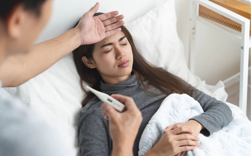 Người lớn bị sốt kiểm tra nhiệt độ trong phòng có máy lạnh