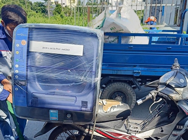 Nhân viên đem máy giặt đến nhà khách hàng