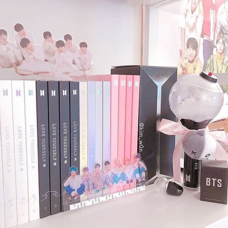 Khung ảnh chứa đĩa nhạc và photocard BTS được đặt trên bàn