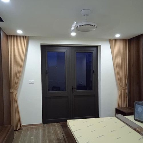 Rèm vải màu vàng ấm áp che chắn ánh sáng tại cửa ra vào phòng ngủ