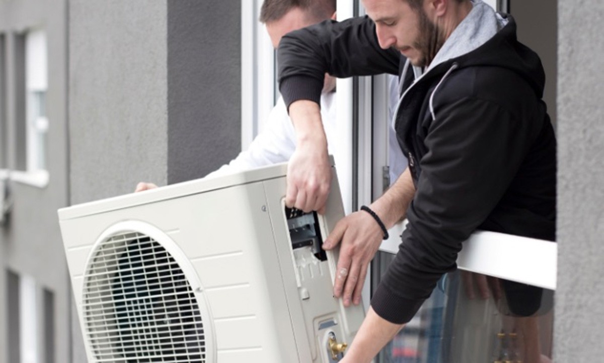 Kỹ thuật viên đang kiểm tra cục nóng máy lạnh để báo giá thay