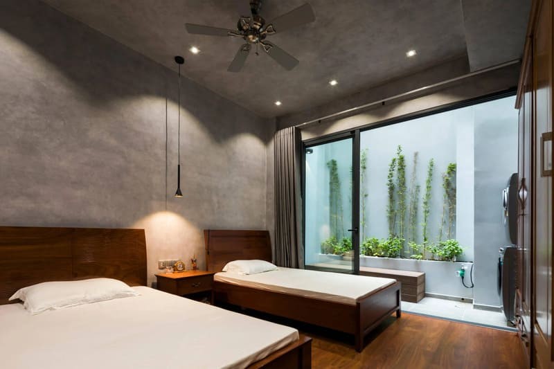 Mẫu phòng ngủ hiện đại cho người già với hai giường đơn, cửa kính lớn mở ra ngoài và tông màu trung tính