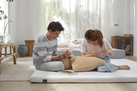 Phòng ngủ tối giản với nệm đặt dưới đất, decor cây xanh và nội thất gỗ tạo không gian thoáng đãng